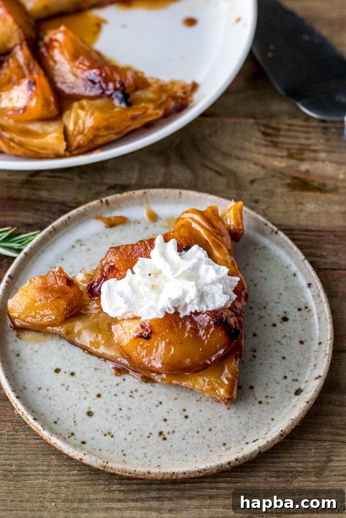 Golden Caramel Apple Tart 14 Slice of tarte tatin with whipped cream on top