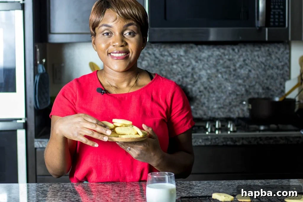 December Dialogue 4 Black woman standing in kitchen holding a plate of cookies