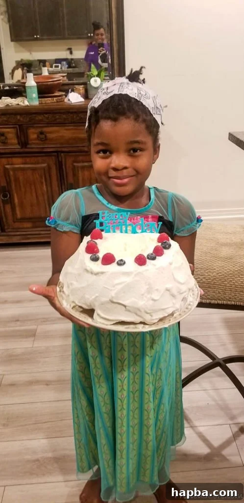 December Dialogue 6 Girl wearing an Anna dress holding a cake that says "Happy Birthday."