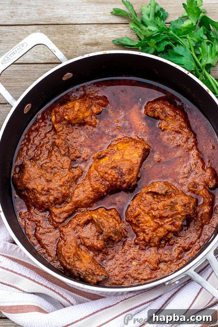 Pan of African Chicken Stew, showcasing its rich red color and tender chicken pieces.